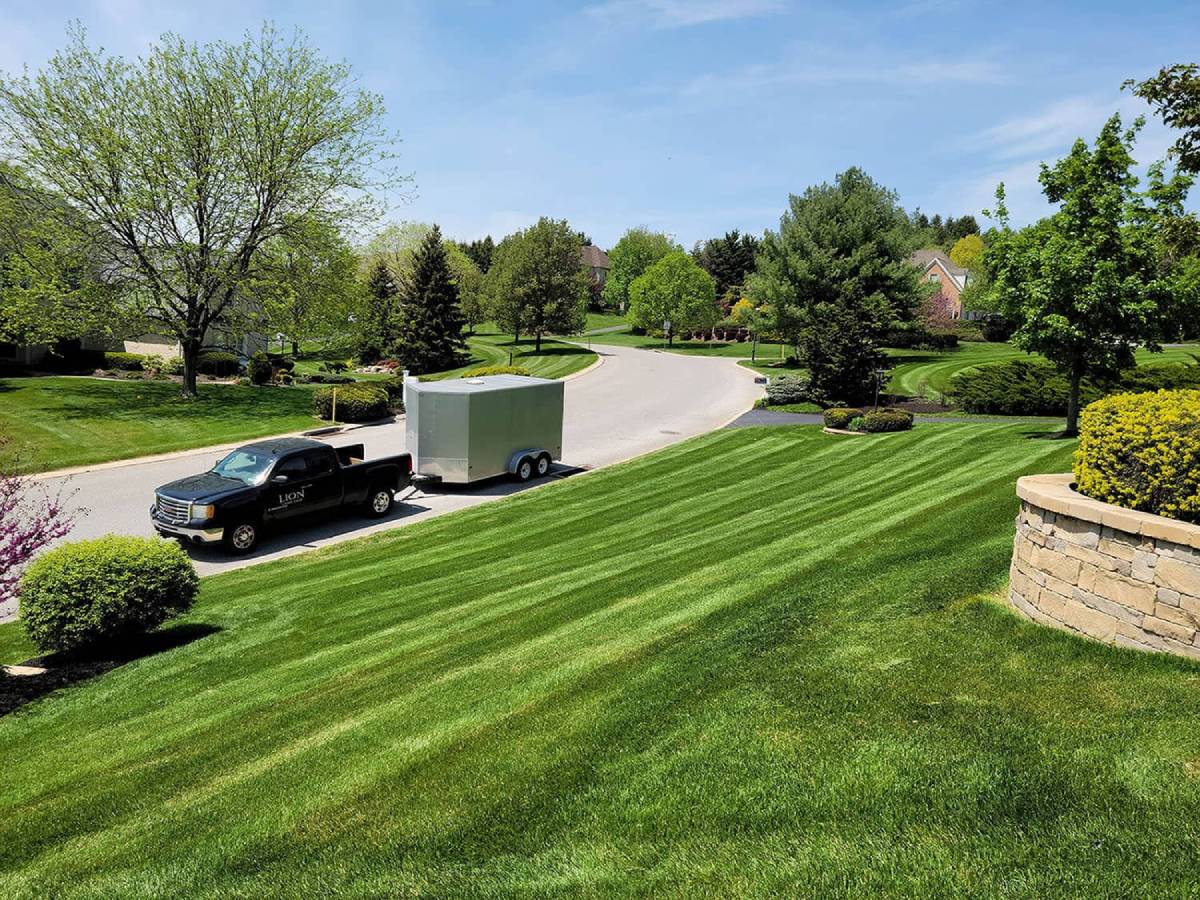 clean mowed lawn with work truck and hauler