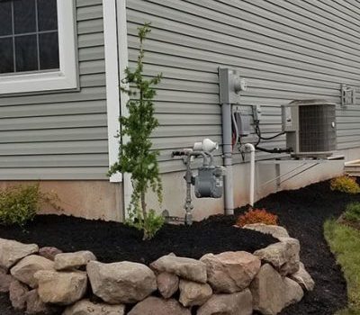 gray home with mulch and landscaping